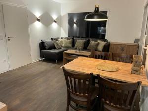 a living room with a table and a couch at Tierpark Entdeckerhäuser in Wagenfeld