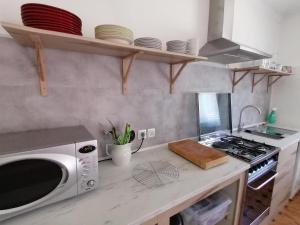 a kitchen with a microwave and a stove top oven at Pine 3 Inn, holiday home, activities and more in Boavista dos Pinheiros