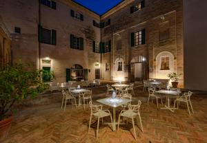 un patio con mesas y sillas en un edificio en Castello Di Monterado en Monterado