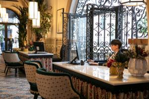 a man sitting at a desk in a hotel lobby at Hotel Casa Palacio Don Ramón in Seville