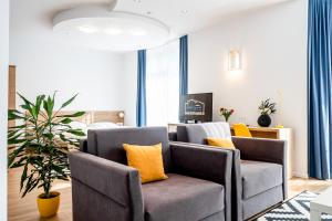 Hotel Squash Dependance في بريفيدزا: غرفة معيشة مع كرسيين وأريكة