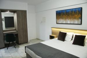 a hotel room with a bed and a desk at Larnaca Bay Suites in Larnaka