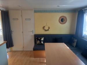 uma sala de estar com um sofá azul e uma mesa em Mobil home 4 personnes em Saint-Paul-lès-Dax