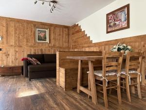 uma sala de estar com uma mesa e cadeiras e um sofá em Hotel Relais Des Glaciers - Adults Only em Champoluc