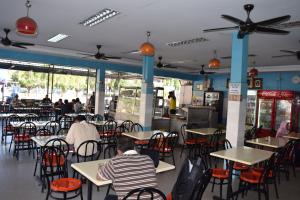 a restaurant with tables and chairs and people sitting at tables at Federal Hotel Kangar Perlis in Kangar