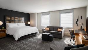 - une chambre avec un lit, un canapé et un bureau dans l'établissement Renaissance Des Moines Savery Hotel, à Des Moines