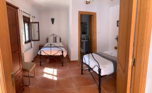 Habitación con 2 camas y mesa. en Lavender Lodge Almeria, en Arboleas