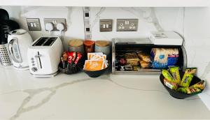 um balcão de cozinha com uma torradeira e alguns alimentos em Reading West Homestay em Reading