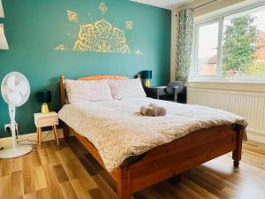een slaapkamer met een bed met een groene muur bij Reading West Homestay in Reading