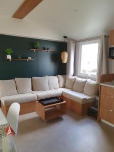 sala de estar con sofá y ventana en Camping du Bois Dormant en Saint-Jean-de-Monts