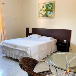 a bedroom with a bed and a glass table at Hotel Villa do Sol in Colinas do Tocantins