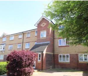 um grande edifício de tijolos com uma árvore em frente em Tastefully decorated 1 bed flat near AbbeyWood em Belvedere