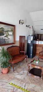 uma sala de estar com um sofá e um frigorífico em Alojamento Dona Inês de Castro em Atouguia da Baleia