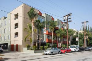 ロサンゼルスにあるN Hollywood 2BR w Gym Pool nr TJ Shops LAX-592のヤシの木が立ち並ぶ路上駐車の建物