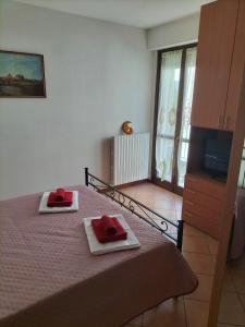 Un dormitorio con una cama con toallas rojas. en Appartamento di Via Marconi, en Spoleto