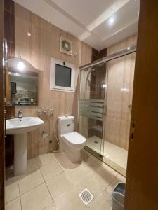 a bathroom with a toilet and a sink and a shower at فخامة الجوهرة للشقق المخدومة ــــ للعائلات فقط ـــــ in Jeddah