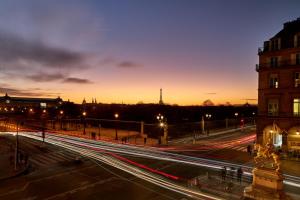 een straat in de stad 's nachts met lichtstrepen bij Hôtel Regina Louvre in Parijs