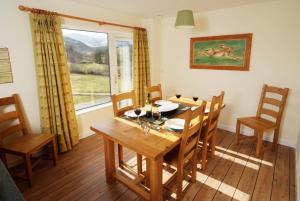 a dining room with a table and chairs and a window at Lang Parrock, Little Langdale in Little Langdale