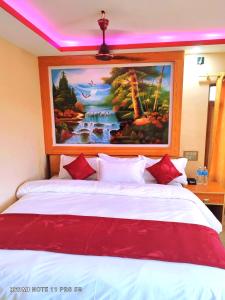 a bedroom with a bed with a painting on the wall at Hotel National Park- A Peaceful Family Home in Sauraha in Chitwan