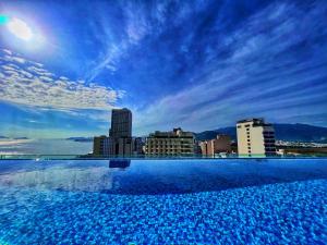 a large swimming pool with a city skyline in the background at Grand Tourane Nha Trang Hotel in Nha Trang