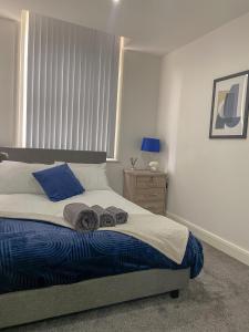 a bedroom with a bed with towels on it at Modern Bradford City Apartment in Bradford
