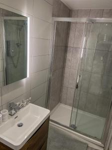 ein Bad mit einer Dusche und einem Waschbecken in der Unterkunft Modern Bradford City Apartment in Bradford