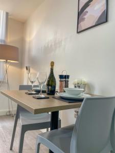 a table with two glasses and a bottle of wine at Modern Bradford City Apartment in Bradford