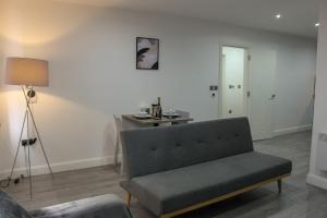 ein Wohnzimmer mit einem Sofa und einem Tisch in der Unterkunft Modern Bradford City Apartment in Bradford