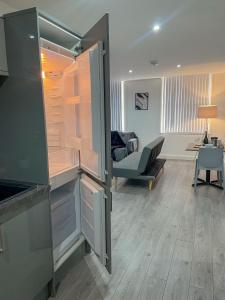 Modern Bradford City Apartment في برادفورد: وجود ثلاجة مفتوحة في غرفة المعيشة مع طاولة
