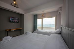 two beds in a room with a view of the ocean at Aerial Hotel & Spa in Vlorë +35 photos