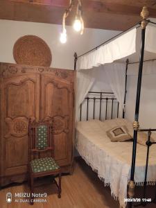 a bedroom with a canopy bed and a chair at Angel's Traditional House 