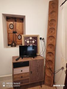 een woonkamer met een tv op een houten standaard bij Angel's Traditional House 