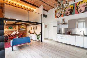 布斯托阿西齊奧的住宿－Pop Art Loft con Giardino Privato，厨房配有白色橱柜和蓝色沙发