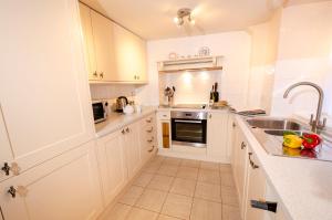 a kitchen with white cabinets and a sink at The Old White Lion, Chapel Stile in Chapel Stile