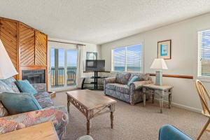a living room with a couch and chairs and a television at High Dunes in Kill Devil Hills