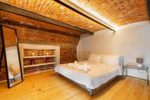 een slaapkamer met een bed in een bakstenen muur bij Pop Art Loft con Giardino Privato in Busto Arsizio