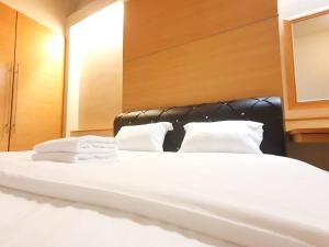 a large white bed with two towels on it at [HERITAGE 5] HOMESTAY Studio 4Pax, FREE WIFI in Seri Kembangan