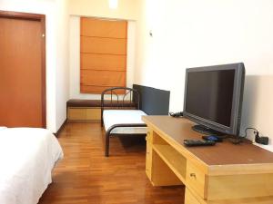 a bedroom with a desk with a television and a bed at [HERITAGE 5] HOMESTAY Studio 4Pax, FREE WIFI in Seri Kembangan