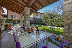 a patio with a table and purple chairs at DesenzanoLoft Luxury suite with jacuzzi and garden in Desenzano del Garda