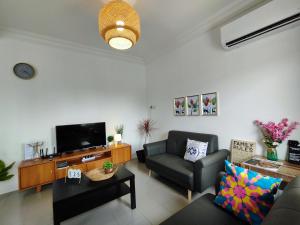 ein Wohnzimmer mit einem Sofa und einem TV in der Unterkunft Grand Height Homestay 3A 10pax 4Rooms in Sibu