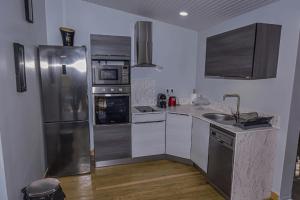 a kitchen with stainless steel appliances and wooden floors at Redoute Paradise in Fort-de-France