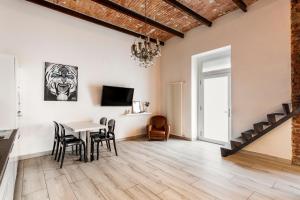 een woonkamer met een tafel en stoelen en een trap bij Pop Art Loft con Giardino Privato in Busto Arsizio