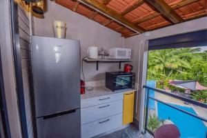 Il comprend un balcon et une cuisine équipée d'un réfrigérateur en acier inoxydable. dans l'établissement Redoute Paradise, à Fort-de-France
