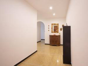 um corredor com paredes brancas, um espelho e uma mesa em La Casetta Verde em Gênova