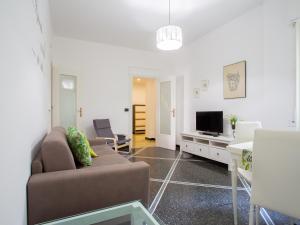 uma sala de estar com um sofá e uma televisão em La Casetta Verde em Gênova