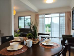 a dining room table with cups and saucers on it at Grand Height Homestay 3A 10pax 4Rooms in Sibu