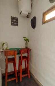 a small table and two stools in a room at Dormir con llamas in Maimará