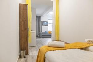 a bedroom with a mirror and a bed with a yellow blanket at Standard 3BR/3BA Apt. near Hauptbahnhof in Vienna