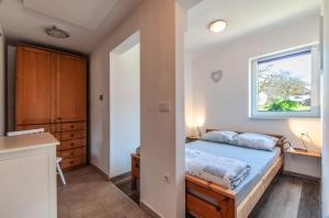 sypialnia z łóżkiem i oknem w obiekcie Apartments JULIA Bohinj w Bohinju