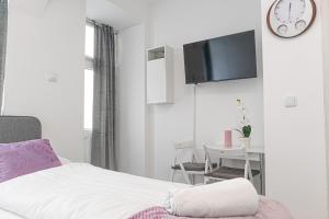 a bedroom with a bed and a table and a clock at Standard 3BR/3BA Apt. near Hauptbahnhof in Vienna